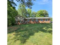 Charming brick home with green shutters and a well-maintained lawn on a sunny day at 1102 Parkwood Dr, Siler City, NC 27344