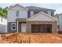 Two-story home featuring stone accents, two-car garage, and neutral-colored siding at 1139 Winding Spring Dr, Mebane, NC 27302