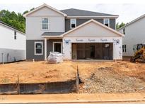 Two-story home exterior showcasing gray and white siding, attached two-car garage, and construction in progress at 1139 Winding Spring Dr, Mebane, NC 27302