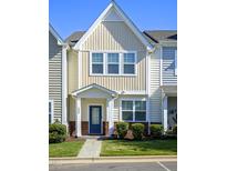 Charming townhome featuring a blue front door and manicured landscaping at 124 Shale Creek Dr, Durham, NC 27703
