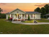 Charming single-story home featuring a covered front porch and well-manicured lawn at 1510 Asbury Church Rd, Sanford, NC 27330