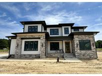 Stunning new home featuring stone and white siding, complemented by dark trim and a welcoming entryway at 200 Broadleaf Ln, Louisburg, NC 27549