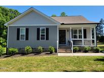 Charming single-story home with well-maintained landscaping and a welcoming front porch at 236 Bragg Ln, Hurdle Mills, NC 27541