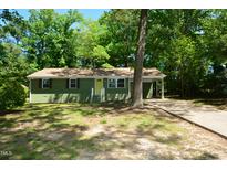 Charming single-story home with a well-maintained lawn, attached carport, and vibrant yellow front door at 2805 Nc 55, Durham, NC 27713