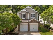 Charming home featuring a brick and siding facade with a two-car garage and mature trees at 3002 Remington Oaks Cir, Cary, NC 27519