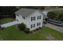 Two-story home with cream siding, black shutters, a nice lawn, and a boat parked in the driveway at 309 Westfield Dr, Dunn, NC 28334