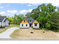 Charming exterior view of home with a well-manicured lawn, driveway, and tasteful landscaping at 310 Pilot Ridge Rd, Zebulon, NC 27597