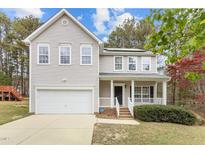 Charming two-story home with a white picket porch, attached garage, and manicured lawn at 338 Howland Ct, Creedmoor, NC 27522