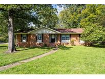 Charming single-story brick home with a well-manicured lawn and mature trees at 401 Crestview Dr Dr, Durham, NC 27712