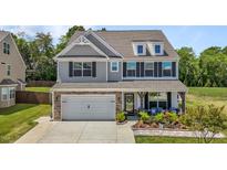 Beautiful two-story home featuring stone accents, a two-car garage, and a charming covered front porch at 528 Brycewood Dr, Burlington, NC 27215