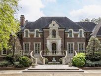 Beautiful brick home featuring a landscaped yard with symmetrical stairs leading to an arched doorway at 5420 Deer Forest Trl, Raleigh, NC 27614