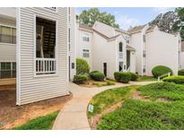 Inviting exterior view of bright condos with a well-maintained lawn and sidewalk leading up to the entrances at 6001 Winterpointe Ln # 102, Raleigh, NC 27606