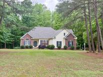 Inviting single-story home with well-maintained landscaping, brick accents, and a serene setting surrounded by mature trees at 6673 Nc 96 W Hwy, Youngsville, NC 27596