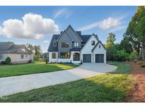 Stunning new construction featuring mixed siding, three-car garage, and manicured lawn at 833 Dunleigh Dr, Burlington, NC 27215