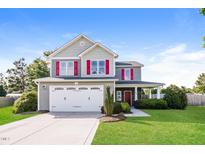 Charming two-story home with a two-car garage, green lawn, and red window shutters at 95 Lockhaven Ct, Cameron, NC 28326