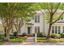 Charming white two-story home with lush landscaping and inviting front entrance at 104 Planetree Ln, Cary, NC 27511