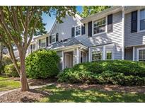 Charming townhome with light gray siding, black shutters, and neatly manicured landscaping in front at 104 Sir Richard Ln, Chapel Hill, NC 27517