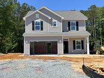 New two-story home features a two-car garage, gray siding, and black shutters, ready for personalization at 169 Pecan Valley Way, Four Oaks, NC 27524