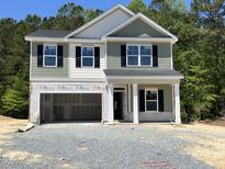 Two-story home with a two-car garage and a covered front porch, still under construction at 183 Pecan Valley Way, Four Oaks, NC 27524
