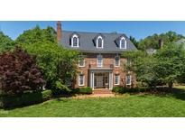 Stately brick home with three dormers, white trim, balcony, and lush green lawn at 205 Buncombe St, Raleigh, NC 27609