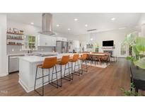 Spacious open-concept kitchen featuring a large island with seating, modern appliances, and light wood flooring at 2540 Beech Gap Ct, Raleigh, NC 27603