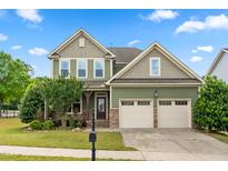 Charming two-story home featuring a two-car garage, stone accents, and a well-manicured lawn at 364 Springtime Fields Ln, Wake Forest, NC 27587