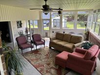 Inviting sunroom featuring comfortable seating, ceiling fans, and abundant natural light from large windows at 405 Taylor Dr, Rocky Mount, NC 27803