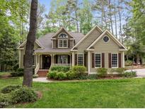 Charming, light green home featuring manicured lawn and mature landscaping at 406 Bakewell Ct, Wake Forest, NC 27587