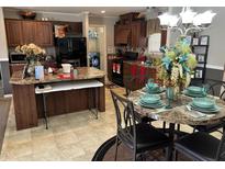 Kitchen and dining area with dark cabinetry, a kitchen island, and a table with decorative place settings at 4855 Mike Ln, Nashville, NC 27856