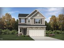 Charming two-story home featuring a stone facade, attached two-car garage, and a beautifully landscaped yard at 521 Morning Light Dr, Angier, NC 27501