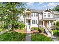 Well-maintained townhome with manicured lawn, charming entryway, and second story balcony at 521 Village Loop Dr, Apex, NC 27502