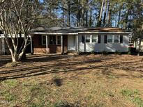 Charming single-story home featuring a brick facade, light gray siding, and a well-maintained front yard in a wooded neighborhood at 620 Wexford Dr, Raleigh, NC 27603