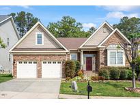Charming single-story home featuring a two-car garage, brick facade, and inviting front garden at 913 S South Bend Dr, Durham, NC 27713