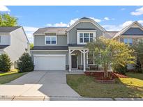 Inviting two-story home featuring a two-car garage, covered porch, and charming curb appeal at 114 Red Robin Rd, Durham, NC 27703