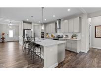 Bright, modern kitchen with gray cabinets, quartz countertops, stainless steel appliances, and a large island with barstool seating at 1816 Sandoval Dr, Durham, NC 27703