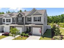 Charming townhome featuring stone accents, a one-car garage, and well-maintained landscaping at 191 Enterprise Dr, Clayton, NC 27520
