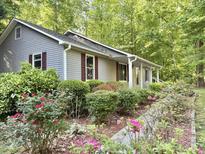 Charming home exterior showcasing a beautifully landscaped front yard with mature flowering plants at 192 Misty Hollow Rd, Timberlake, NC 27583