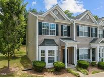 Inviting townhome featuring charming architectural details and manicured landscaping at 2713 Wyntercrest Ln, Durham, NC 27713