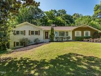 Charming single-story home with brick and siding, front yard with mature trees and manicured landscaping at 3009 Hillmer Dr, Raleigh, NC 27609