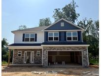 New construction with stone accents, blue shutters and siding under a clear, sunny sky at 327 Bishop Ln, Sanford, NC 27330