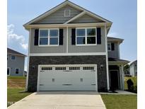 Charming two-story home with gray siding, stone accents, black shutters, and a spacious two-car garage at 332 Bishop Ln, Sanford, NC 27330