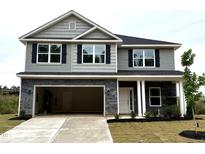 Two-story home with stone accents, black shutters, attached garage, and manicured lawn at 356 Bishop Ln, Sanford, NC 27330