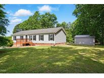 Charming single-story home with a well-maintained lawn and a small storage shed in the backyard at 4467 Virgilina Rd, Roxboro, NC 27574