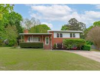 Charming brick two-story home with manicured lawn and mature trees in a quiet neighborhood at 5144 Jeffries St, Raleigh, NC 27606