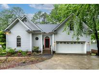 Charming two-story home with a red front door, white trim, an attached garage, and well-maintained landscaping at 6 Chelan Ct, Durham, NC 27713