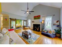 Bright living room with high ceilings, fireplace, and sliding barn doors to the primary bedroom at 6 Chelan Ct, Durham, NC 27713