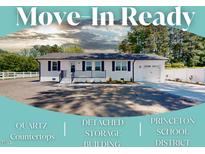 Charming single-story home features a freshly painted exterior, dark shutters, and a detached garage at 6715 Princeton Kenly Rd, Princeton, NC 27569