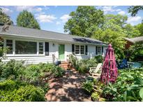 Charming one story home with a brick walkway and beautifully landscaped front yard at 708 W Main St, Carrboro, NC 27510