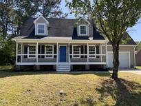 Charming two-story home with a covered front porch and a vibrant blue front door at 717 Papsworth Ct, Fuquay Varina, NC 27526