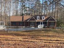 Charming single-story brick home with a well-maintained lawn and surrounding woods at 80 White Deer Ln, Henderson, NC 27537